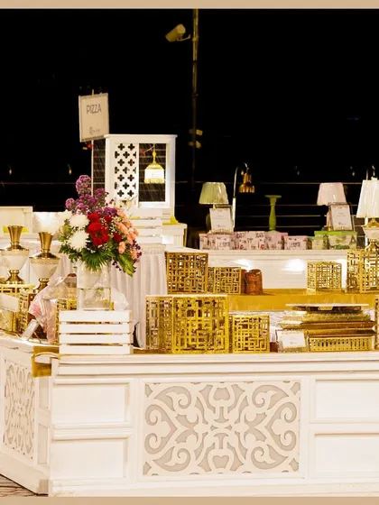 A close-up of our detailed buffet station decor. Intricately designed white counters are paired with golden accents and ambient table lamps to create a luxurious feel.