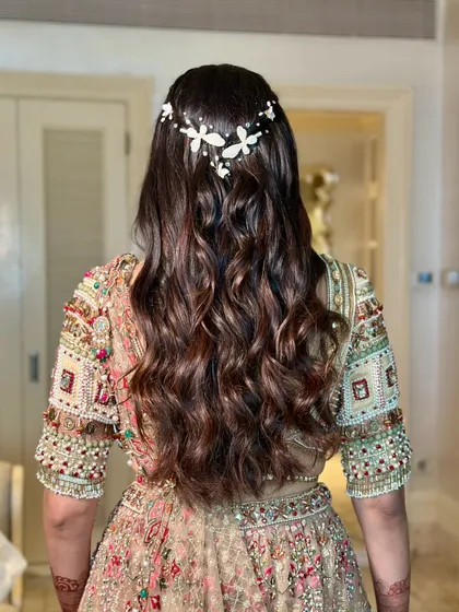 A view of the beautiful, soft waves and butterfly hair accessory. The hairstyle perfectly complements the romantic and elegant feel of the engagement look.