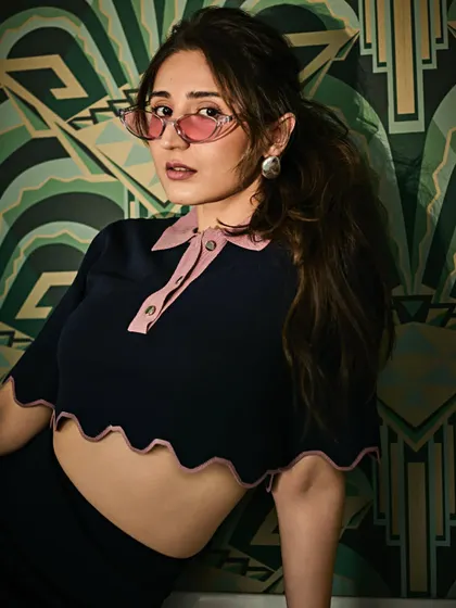A playful and retro-inspired look. The scalloped details on this crop top and the tinted glasses give it a fun, vintage feel.
