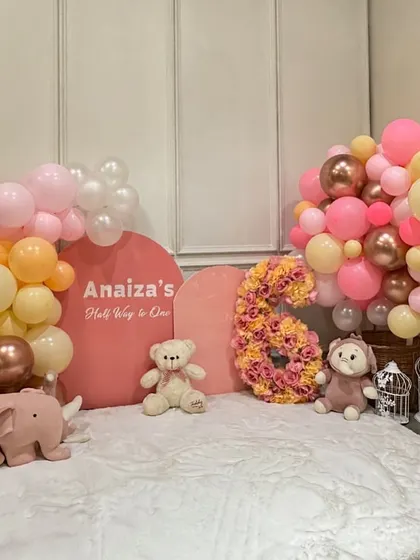 Celebrating "Half Way to One" is such a special milestone. We designed this adorable pink and peach themed setup for a 6-month birthday, complete with a floral number '6' and cute stuffed animals.