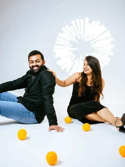 A candid shot of a couple laughing together during a playful studio shoot with oranges. Capturing these unscripted moments of joy is what I love most.