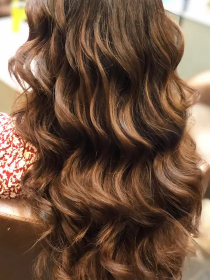 A detailed shot of the warm brown balayage, highlighting the interplay of light and dark tones within the curls.