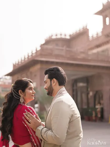 A quiet, intimate portrait set against the backdrop of heritage architecture. The focus is on the couple's loving gaze and the story they share.