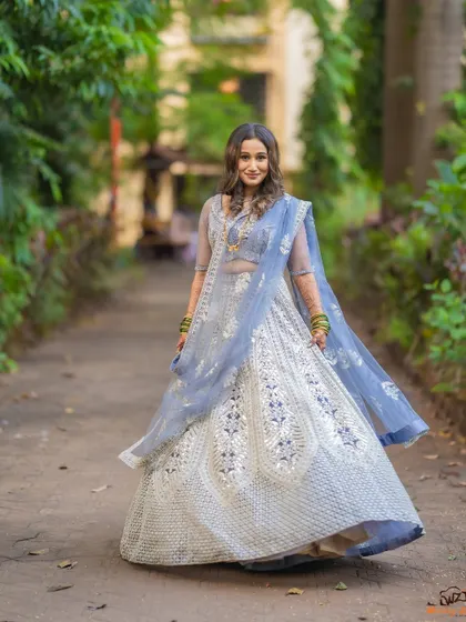 A beautiful shot of the bride twirling in her stunning silver and blue lehenga, showcasing the outfit in its full glory.