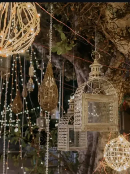 We love using unique lighting elements, like these rustic wicker and metal lanterns mixed with fairy lights, to add texture and a warm, magical glow to outdoor evening events.