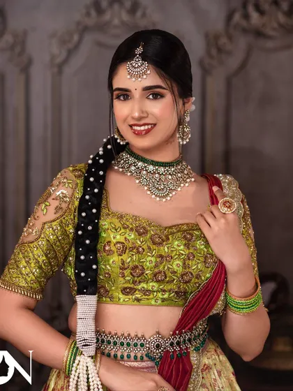 A smiling portrait of the model, radiating joy. The Kundan jewellery adds a touch of traditional elegance to her modern lehenga look.