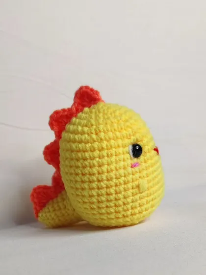 The side view of the yellow dino, showing its orange spikes.