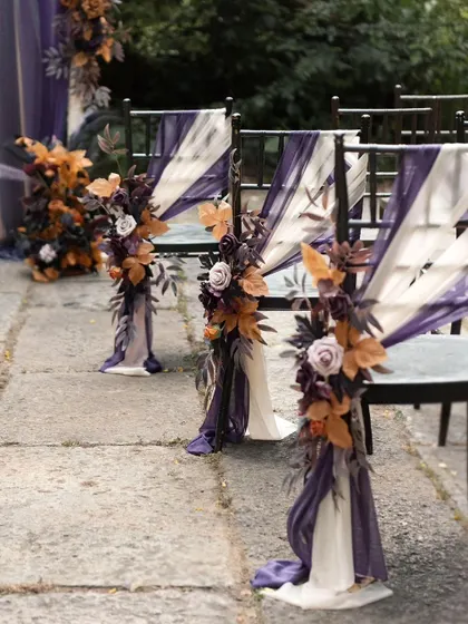 For a wedding ceremony, even the smallest details matter. I adorned these guest chairs with flowing purple and white fabric and floral accents to match the main wedding arch, ensuring a cohesive and beautiful look.