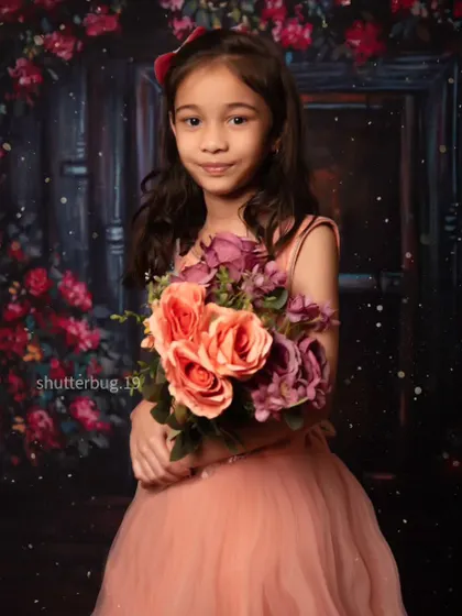 This young lady is holding a bouquet of flowers, looking sweet and poised for her portrait.