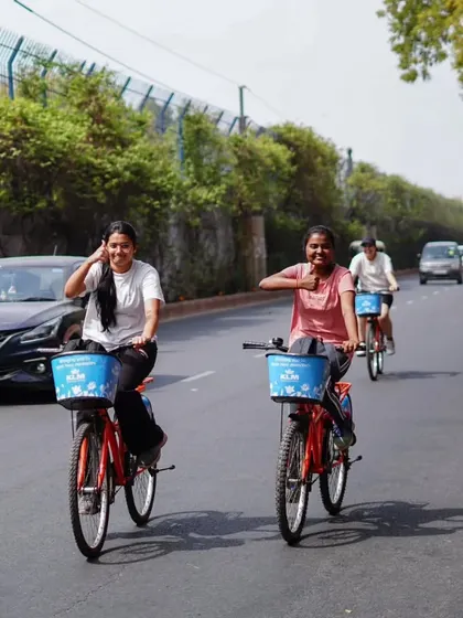 Smiles for miles. Two riders share a happy moment while cycling through the city. The simple joy of riding with a friend is what our tours are all about.