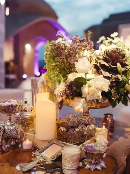 A detail shot of the Sufi Night decor, featuring antique silver containers, ornate mirrors, and lush floral arrangements with a mix of white and deep purple flowers.