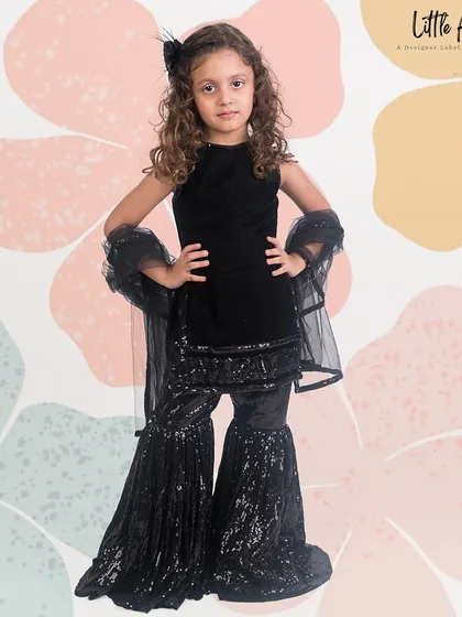 An elegant black velvet garara set, featuring a simple top and heavily sequined pants for a chic party look.