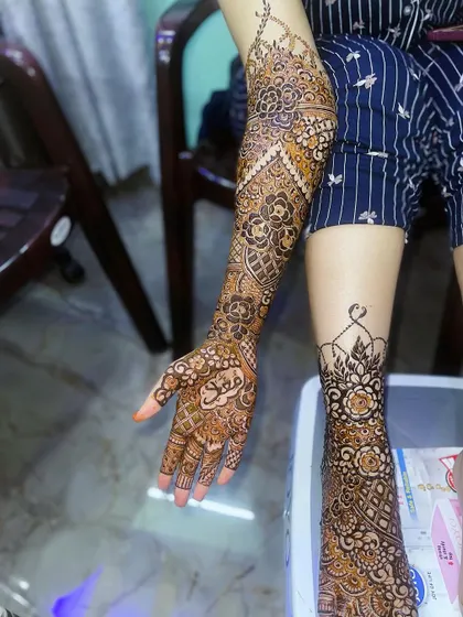 This shot shows the full bridal henna, with the arm design and the foot design visible, giving an idea of the complete package.