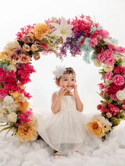 The purest form of joy and innocence is captured in this little angel's smile as she sits in our floral wreath.