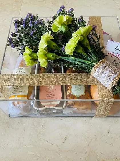 The complete Mother's Day breakfast hamper, all wrapped up and ready to go. The clear acrylic box is tied with a rustic burlap ribbon, keeping the beautiful bouquet and treats visible.