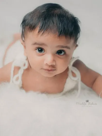 A perfect tummy time pose on a soft, cloud-like blanket. This is a classic shot for a 5-month milestone session.