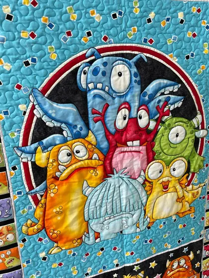 A close-up of the friendly monsters on the themed quilt.