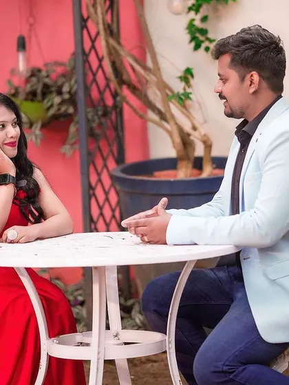 A sweet cafe scene, with the couple engaged in conversation at a quaint outdoor table.