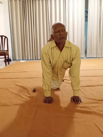Moving through a tabletop posture with focus and stability during his personal yoga asana session.