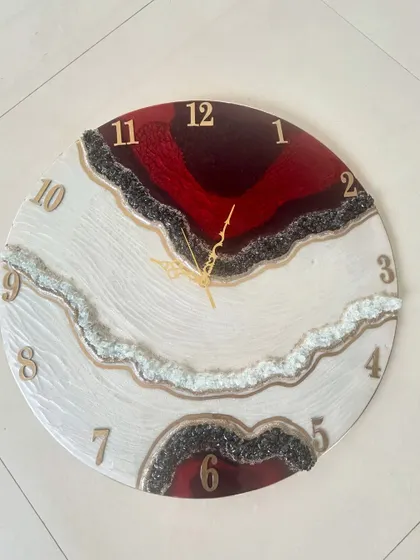 A modern geode-style clock with bold red and black sections, accented with lines of black and clear crystals for a dramatic effect.
