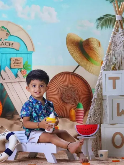 A toddler enjoys an ice cream treat while sitting on a lounge chair in our vibrant and fun beach-themed studio set.
