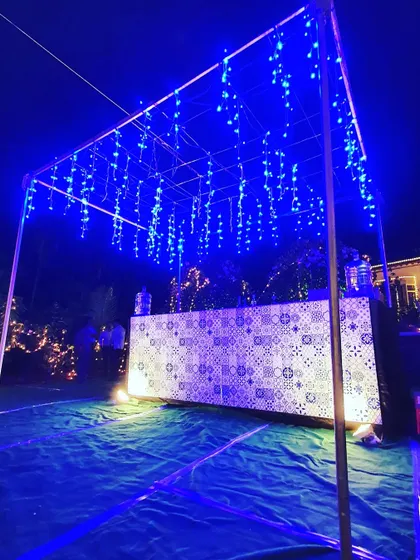 We set up this stylish bar for Ananya and Rakshith's engagement party. The bar front features a modern tile pattern, illuminated by a canopy of cascading blue fairy lights that created a cool, contemporary vibe.