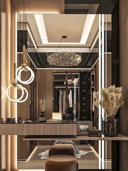 This walk-in closet and dressing area shows my approach to creating organized luxury. I used glass-fronted wardrobes with internal lighting, a dedicated vanity table, and elegant chandeliers to design a space that is both beautiful and highly functional.