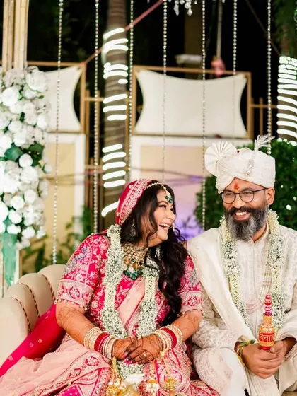A moment of shared laughter on the wedding stage. After the main rituals, the couple relaxes and enjoys a lighthearted moment, showcasing the candid joy I love to capture.