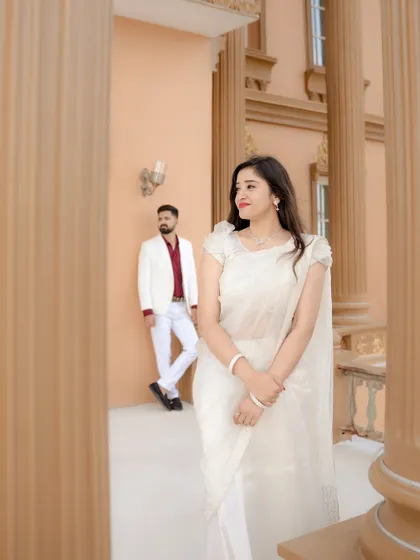 A beautifully composed shot using the pillars of the building to frame the couple. This technique adds depth and a sense of stolen glances, making the portrait feel more intimate and cinematic.