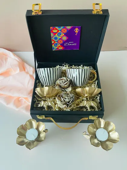 We love creating gifts that are both beautiful and useful. This elegant black suitcase hamper features a set of modern ceramic cups and golden elephant t-light holders, perfect for a sophisticated festive gift.