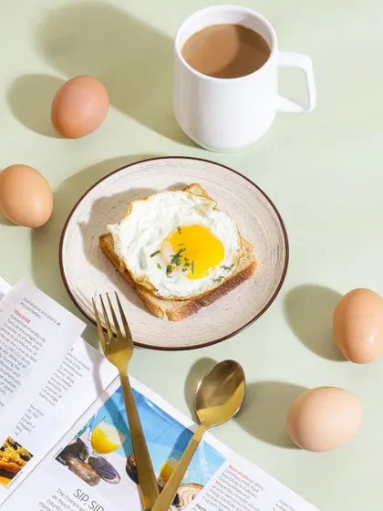 A classic breakfast scene styled for an egg brand, complete with a newspaper and coffee. This top down flatlay shot creates a relatable morning moment, showcasing the product as part of a perfect start to the day.