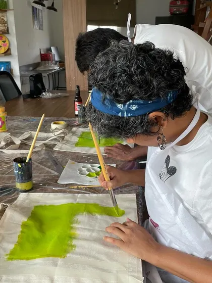A guest painting her own design on a tote bag during one of our open house workshops. It's a great way to create a unique and functional piece of art.