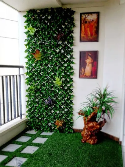 Even a small balcony can become a charming green corner. Here, I used artificial turf with square pavers to create a patterned floor, complemented by a leafy trellis wall for added privacy and greenery.