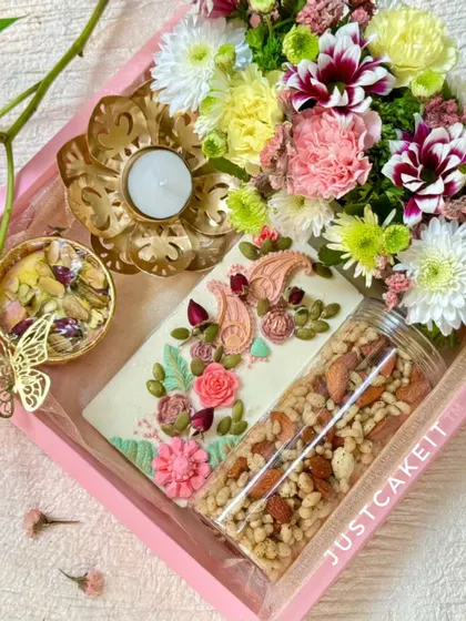 My artisanal gift hampers are perfect for any festival or special occasion. This 'Festive Bloom' Diwali hamper combines hand-painted white chocolate, a savory crunch mix, and fresh flowers for a truly elegant gift.