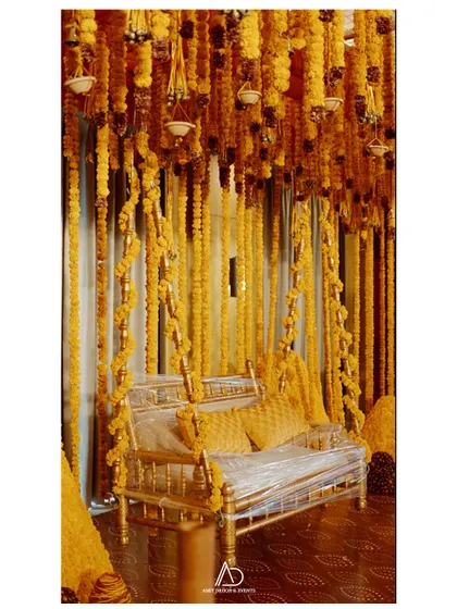 A traditional Indian swing (jhoola) decorated lavishly with strings of bright yellow marigolds, creating a perfect photo spot for a Mehendi or Haldi ceremony.