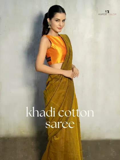 Breezy, breathable, beautiful. This Khadi cotton saree, paired with a vibrant sleeveless orange blouse, is your best pick for sunny days and summer soirées. Stay cool, stay classic.