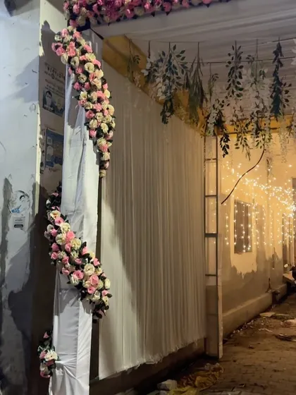 A detail shot of the wedding alley decor, showing the floral arrangements on the draped entrance structure.