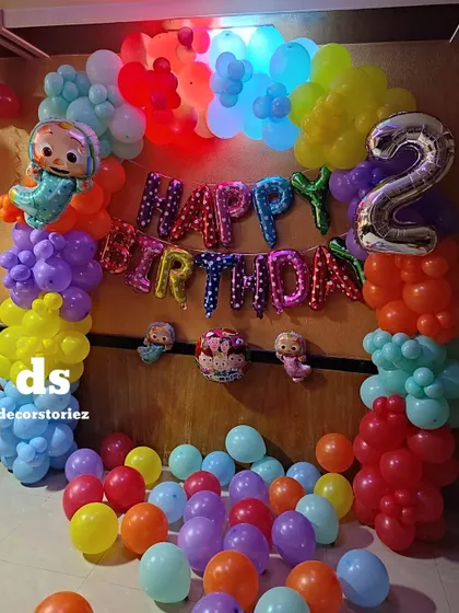 A close-up of the Cocomelon birthday setup, highlighting the 'Happy Birthday' foil balloons and the number '2' foil balloon, making it perfect for a toddler's party.