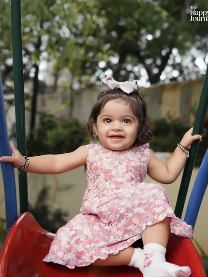 A big, happy smile from a toddler on a slide. Outdoor sessions are perfect for capturing this kind of natural, uninhibited joy.