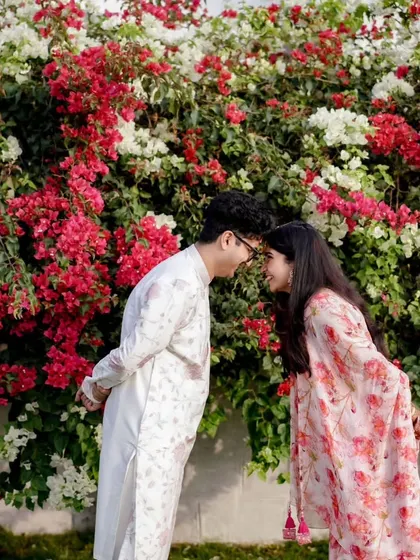 A romantic moment from a Mehendi function, with the couple framed by a beautiful bougainvillea wall that adds a natural touch of color.