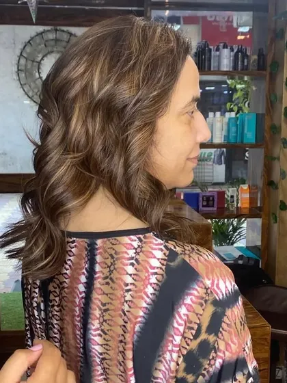 The client is admiring her new color. My goal is always to create a look that not only looks great but also makes the client feel confident and happy.