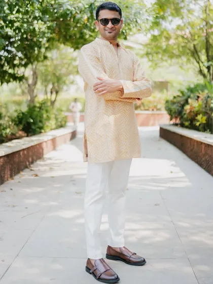 The groom's look for the welcome event featured a subtle bandhani print kurta in a contrasting yellow, complementing the bride's playful pink and ivory outfit.