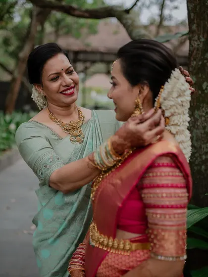 A mother's loving touch as she helps her daughter get ready. These quiet, behind-the-scenes moments are an essential part of the wedding story we tell.