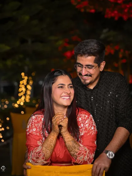 A joyful portrait of the couple under the warm lights of their Mehandi night celebration.