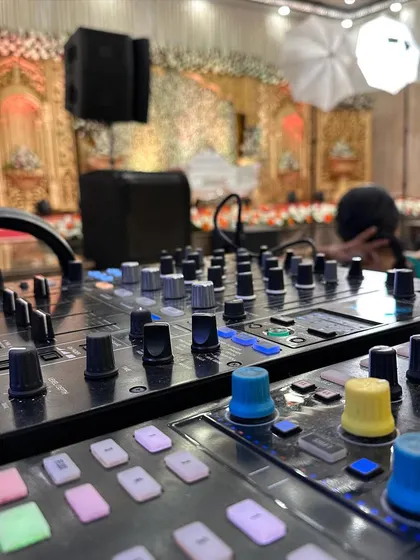 A view from behind my console during a wedding reception. You can see the professional-grade equipment I use to deliver a flawless performance, with the beautifully decorated stage in the background.