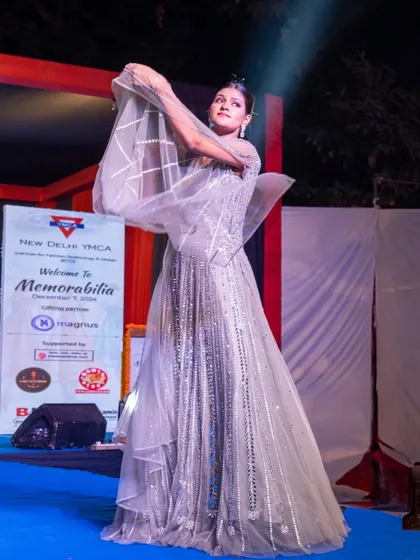 A model in a shimmering silver gown with unique, structured sleeves, showcasing modern design aesthetics.