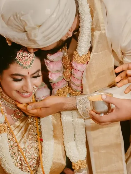 A beautiful moment from a South Indian wedding ceremony. The groom gently blesses the bride, their faces full of emotion and reverence for the ritual.