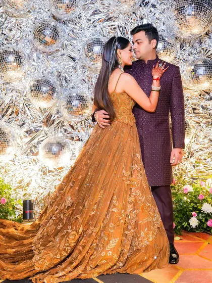 An intimate couple portrait against a backdrop of disco balls. This creative shot captures a romantic moment amidst the glitz and glamour of the sangeet night.