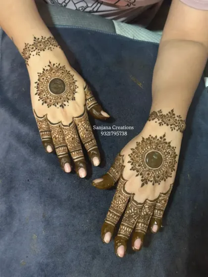 A classic party mehndi design with a bold central mandala and filled-in fingertips for a dramatic look.