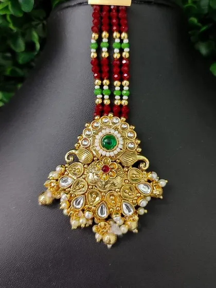 A unique maang tikka featuring a pendant with peacock motifs and colorful beadwork. This piece is perfect for adding a vibrant touch to your look.